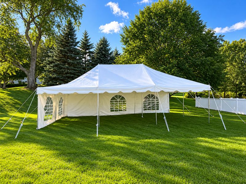 20 by 30 pole tent with cathedral-window sidewalls on a green lawn
